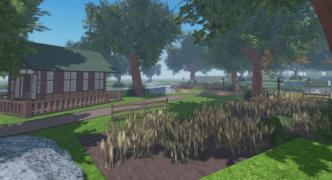 A wooden building with a green roof sits beside a path leading to a field of tall grass and trees.